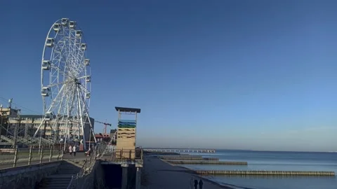Pedestrian path on the waterfront against the background of the Ferris wheel Stock Footage 163346455