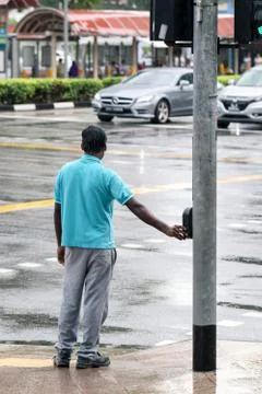 Pedestrian pushing button on traffic light pole to get green sign for safely Stock Photos