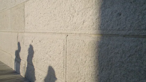 Pedestrian shadows cast on a brick wall Video stock 316564315