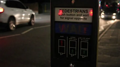 Pedestrian traffic light control panel at night, cars passing in background Stock Footage 251968154