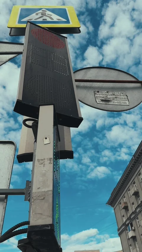 Pedestrian traffic light with red and green signals under blue cloudy sky Video stock 318675604