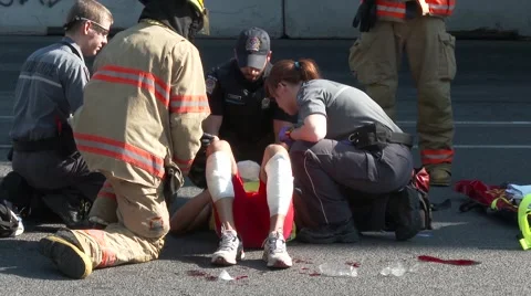 Pedestrian victim of car accident being helped by emergency personel Stock Footage