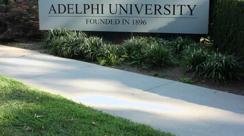 Pedestrian walking by Adelphi University sign (2 of 2) Stock Footage 32625765