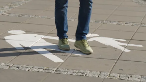 Pedestrian walking toward camera over painted pedestrian path marking 스톡 동영상 344187182