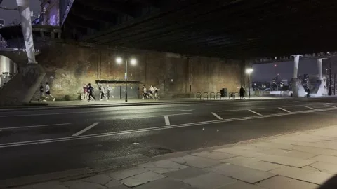 Pedestrian walking under bridge at night in London street scene Video stock 331827507