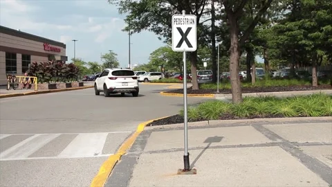 Pedestrian x vertical rectangle white black sign on metal post with parking lot Stock Footage 249754764