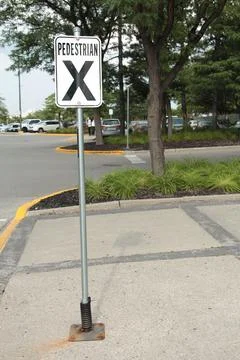 Pedestrian x vertical rectangle white black sign on metal post with parking lot Foto stock