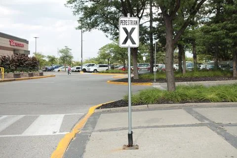 Pedestrian x vertical rectangle white black sign on metal post with parking lot Foto stock