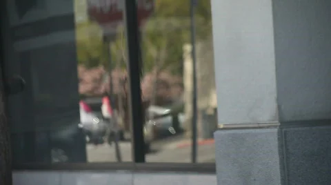 Pedestrians and cars reflected in window Stock Footage