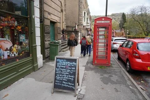 Pedestrians And Red Phone Booth On A Street In Matlock Bath, England. Stock Photos