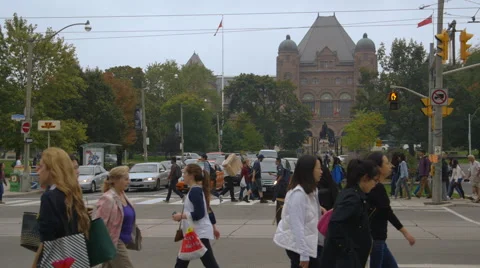Pedestrians cross intersection infront of Queens Park in Toronto Stock Footage 44266914
