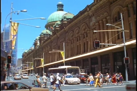 Pedestrians cross the street near an ornate building in downtown Sydney, Stock Footage