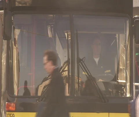 Pedestrians crossing in front of public bus, buses move past camera Stock Footage 86743100