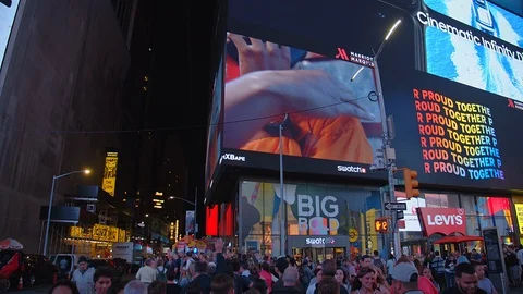 Pedestrians crossing street crowded New York City Times Square displays handheld Stock Footage