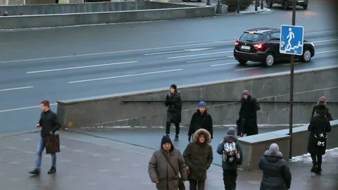 Pedestrians enter and exit the underground passage near the road Stock Footage 105681035