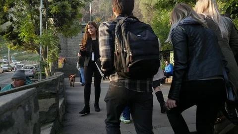 Pedestrians on hill sidewalk Stock Footage 77051350