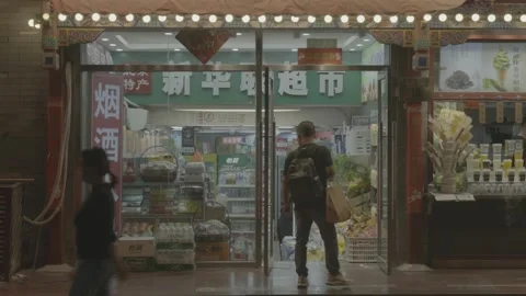 Pedestrians Pass Local Convenience Storefront in Wangfujing at Night Stock Footage 340480722