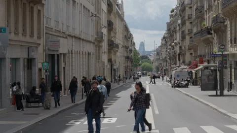 Pedestrians walk along sidewalks and cross the road on Rue de Saint-Petersbourg Stock Footage 336723980