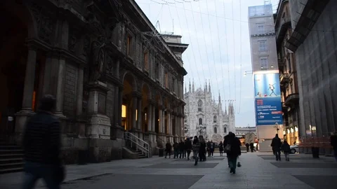 Pedestrians walk to and from the Duomo Cathedral on via Mercanti Stock Footage 98737553