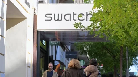 Pedestrians Walk Past Swatch Store in Madrid, Spain: Swiss Watchmaker Brand Stock Footage 322733763