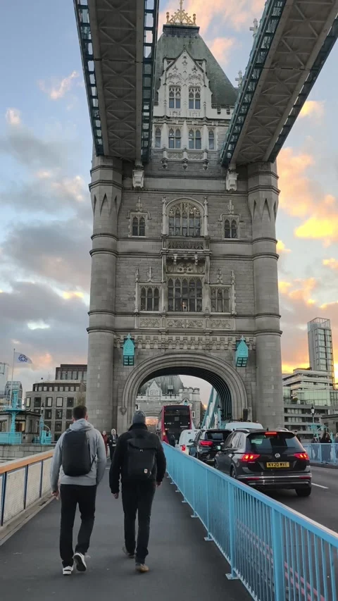 Pedestrians walking across Tower Bridge in London during sunset Stock Footage 323590132