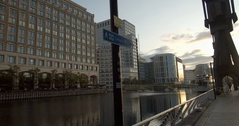 Pedestrians walking along the quay of North Dock Canary Wharf London Stock Footage