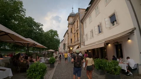 Pedestrians walking down a charming cobblestone street Stock Footage 346240329