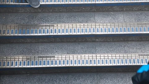 Pedestrians walking down the metal steps to the London underground Stock Footage 98753971