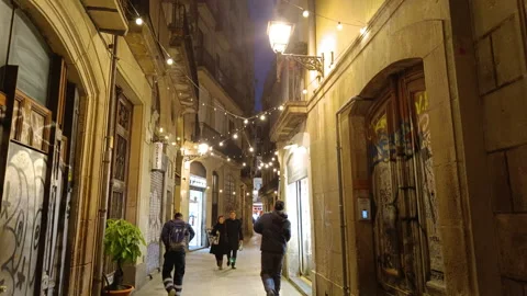Pedestrians walking down a narrow,  old alley in a Barcelona  at night Video stock 327861287