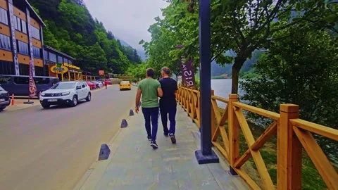 Pedestrians walking down a sidewalk next to. Stock Footage 284635668