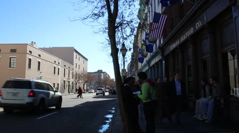 Pedestrians walking in front of shops while cars pass by through charleston town Stock Footage 45732809