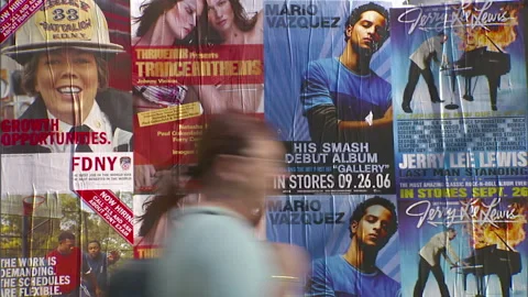 Pedestrians walking past adverting posters Video stock 144649668