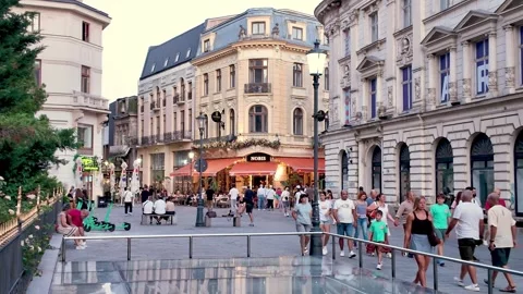 Pedestrians walking on a public square in Old Town Bucharest with historic Stockbeeldmateriaal 343416578