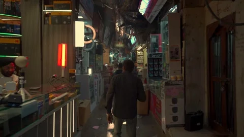 Pedestrians walking through a narrow electronics and camera market alley Stockbeeldmateriaal 341109722