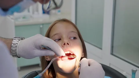 Pediatric dentist examining teeth with mirror for young girl close up. Vídeo Stock 340630459