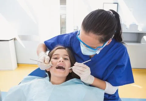 Pediatric dentist using dental explorer and angled mirror Stock Photos