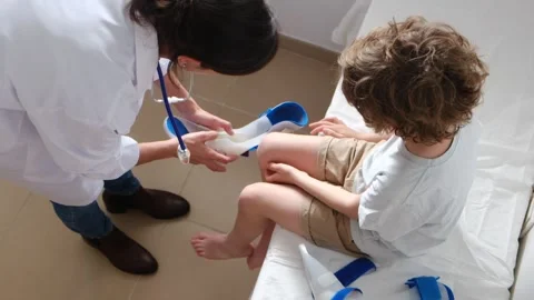 Pediatric orthopedist carefully examines a boy with a disability Video stock 271188198