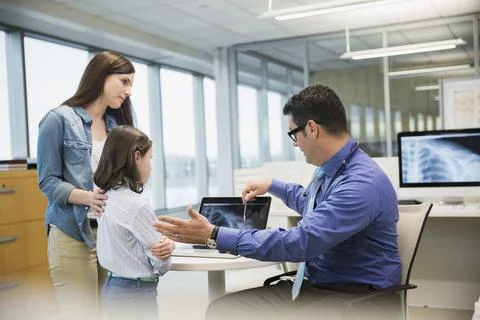Pediatrician explaining shoulder x-rays mother and daughter Stock Photos