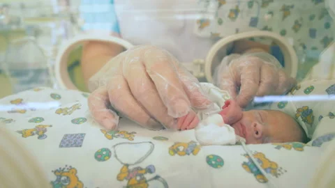 Pediatrician is moving tiny hands of a newborn baby Stock Footage 91731235