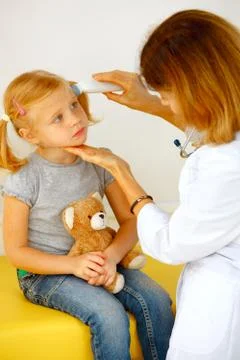 Pediatrician taking temperature with thermometer. Stock Photos