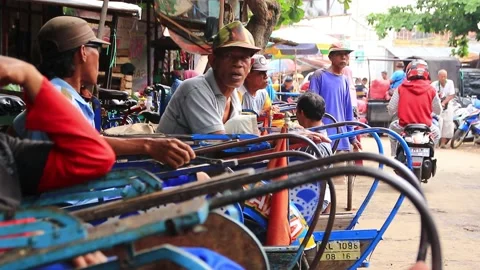Pedicab driver during a break by chatting with friends Stock Footage 142816185