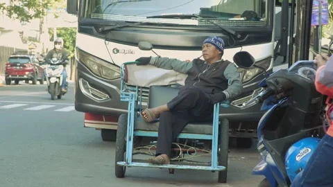 Pedicab driver is sitting relaxed on his rickshaw while waiting for passeng.. Stock-Footage 241997481