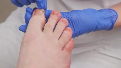 A pedicure master, cuts the thumbnail with professional scissor Stock Footage 272516727