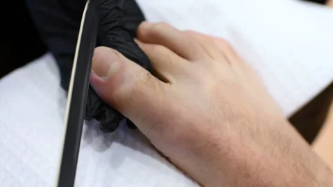 Pedicure master doing finger nail care customer men on spa salon background Stock Footage 104411634