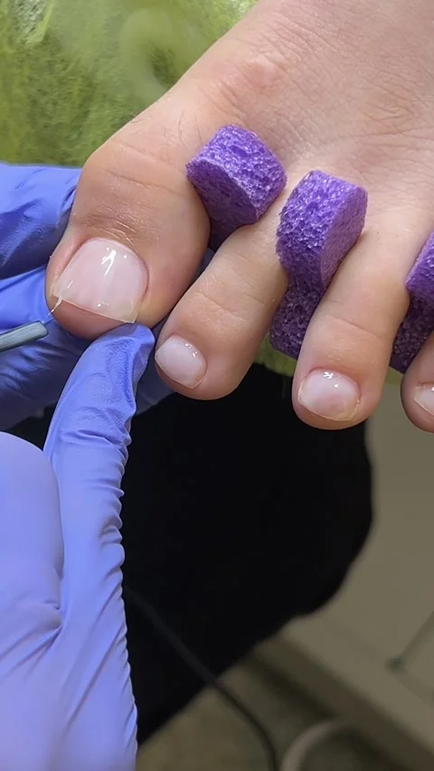 Pedicure master doing pedicure procedure for women, nipping cuticles with Stock Footage 290800502