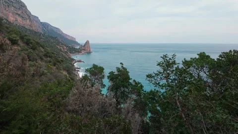 Pedra Longa Sea Stack Beyond Coastal Forest and Turquoise Mediterranean Waters Stock Footage 339032421