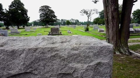 Peeking behind a headstone in a graveyard Stock Footage 245501545