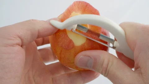 Peel the apple with your hands using a vegetable peeler. Wash and peel fruits Stock Footage 263366239