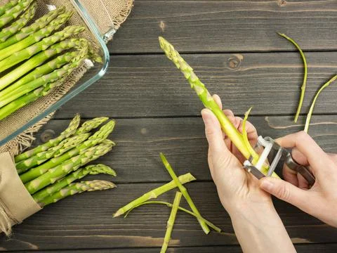 Peel the asparagus. Clean the asparagus. Raw ingredient. Top view. Flat lay. Stock Photos