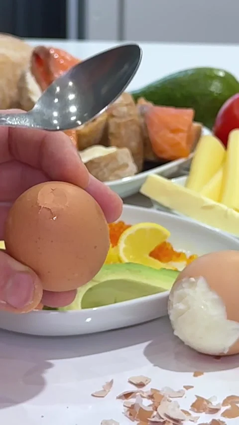 Peel a boiled egg Overhead view of fair skinned person focused on peeling shell Stock Footage 327293797